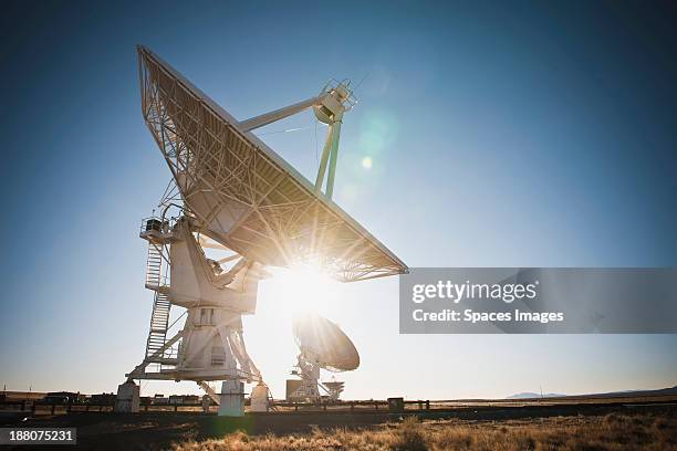 sun shining behind satellite dish in desert, socorro, new mexico, united states - radio telescope stock pictures, royalty-free photos & images