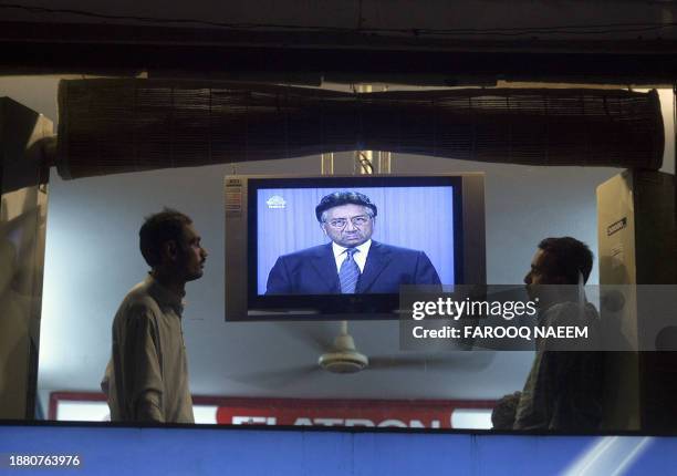 Pakistan viewers watch a television showing an image of President Pervez Musharraf during his address to the nation on radio and State Television in...