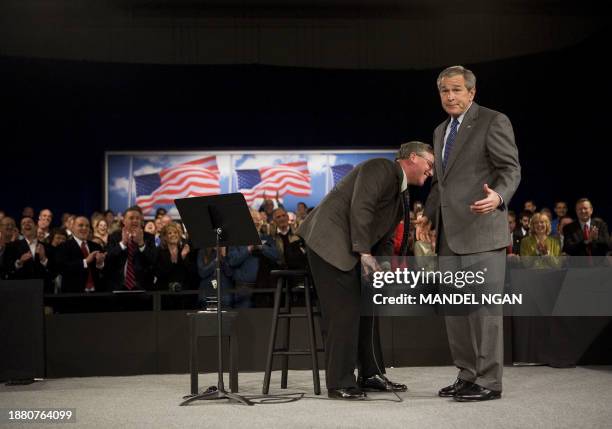 President George W. Bush gestures after Steve Bruns, President Emeritus of Tipp City Chamber of Commerce, dropped the microphone after introducing...