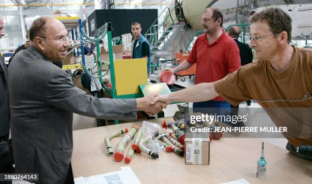 Serge Dassault, président d'honneur du groupe Dassault aviation serre la main aux techniciens chargés du montage du Falcon 7X, le 27 avril 2007 à...