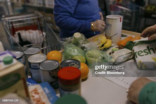 Volunteer helps a guest checkout groceries at the Neighbor to Neighbor food pantry in Greenwich, Connecticut, US, on Monday, Nov. 20, 2023. Neighbor...