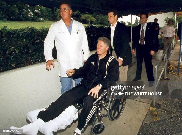 President Bill Clinton leaves St Mary's Medical Center in West Palm Beach, FL, in a wheelchair after being treated for a damaged tendon in his knee....