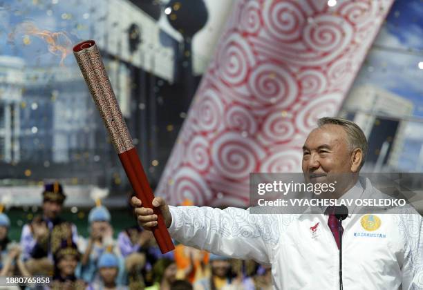 Kazakhstan's President Nursultan Nazarbayev holds the Olympic torch at the Medeu speedskating stadium, up in the mountains outside Almaty on April...