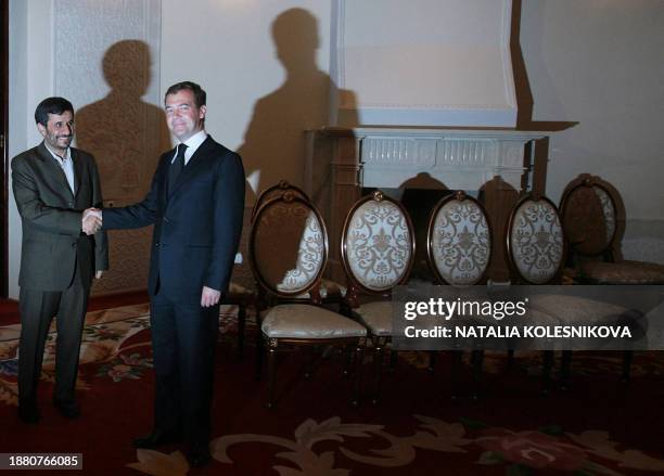 Russian President Dmitry Medvedev shakes hands with Iranian President Mahmoud Ahmadinejad during their bilateral meeting in Dushanbe on August 28,...