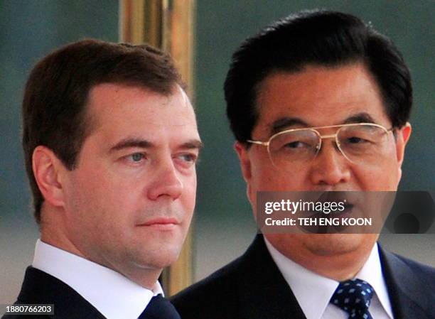 Chinese President Hu Jintao chats with visiting Russian President Dmitry Medvedev as they inspect the guard of honor during a welcoming ceremony at...