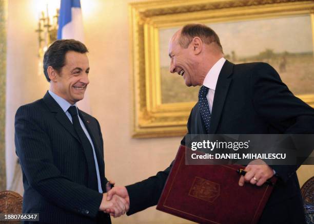 French President Nicolas Sarkozy and his Romanian counterpart Traian Basescu shake hands during the exchange of official documents pertaining to the...