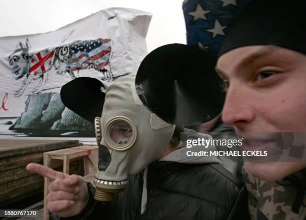 Members of the pro-Kremlin youth group Young Russia dressed as Mickey Mouse stand near a banner showing US President George Bush drawn as a ram...