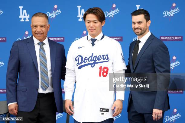 Yoshinobu Yamamoto, center, poses for a photo with manager Dave Roberts, left, and general manager Brandon Gomes, as he is introduced during a press...