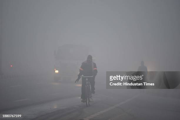Vehicle plying slow speed amid dense foggy weather at South West Delhi near Samalka red light on December 27, 2023 in New Delhi, India. Dense fog...