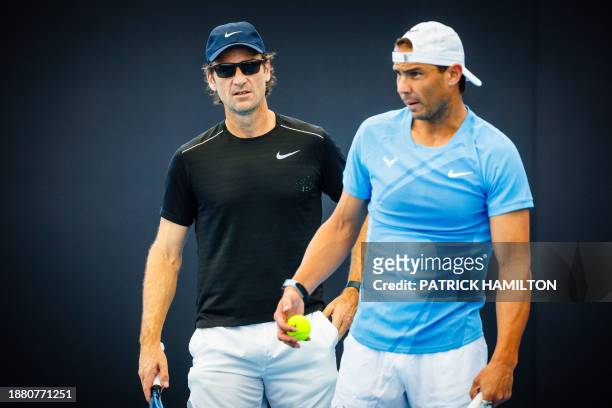Spain's Rafael Nadal and his coach Carlos Moya attend a training session ahead of the Brisbane International tennis tournament in Brisbane on...