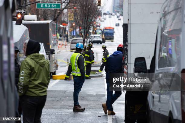 Workers and firefighters carry out work due to the asbestos concerns from steam pipe leak in midtown Manhattan of New York, United States on December...