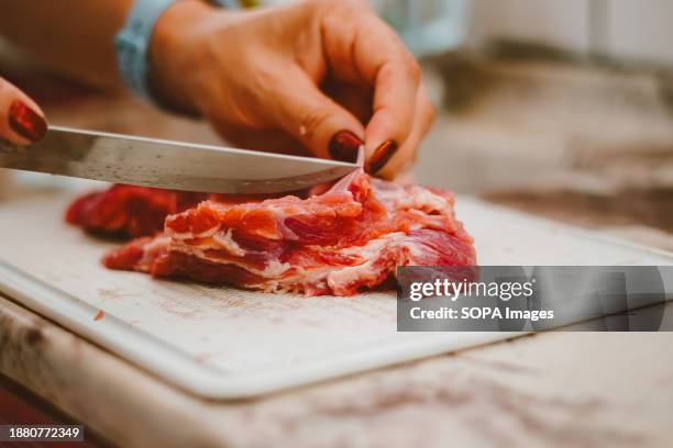 Cook uses a knife to remove fat from a piece of beef. Beef provides essential vitamins and minerals such as vitamin B12, zinc, selenium, iron,...