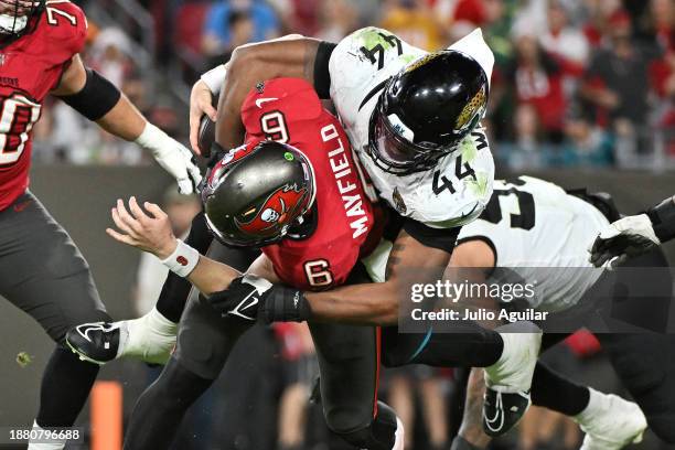Baker Mayfield of the Tampa Bay Buccaneers is sacked by Travon Walker of the Jacksonville Jaguars during the fourth quarter at Raymond James Stadium...