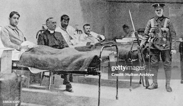 British army soldier stands guard over Irish republican prisoners in a temporary hospital at Dublin Castle following the Easter Rising, Ireland,...