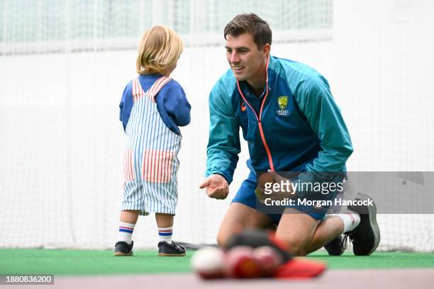 Pat Cummins plays a game with his child, Albie during an Australian Test squad nets session at Melbourne Cricket Ground on December 25, 2023 in...