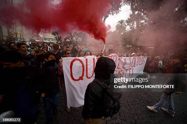 Protester lights a flare as demonstrators march during a student rally in downtown Rome on November 15, 2013. Students were protesting all over the...