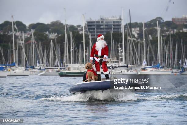 Father Christmas and his dog Rudolph arriving in Sydney Harbour to deliver gifts to the participants of the Rolex Sydney to Hobart yacht race which...