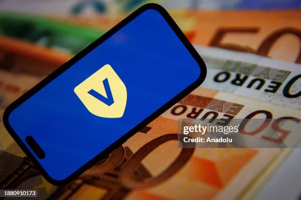 In this photo illustration, logo of Vestwell is displayed on mobile phone screen in front of the computer screen displaying Euro icon in Ankara,...