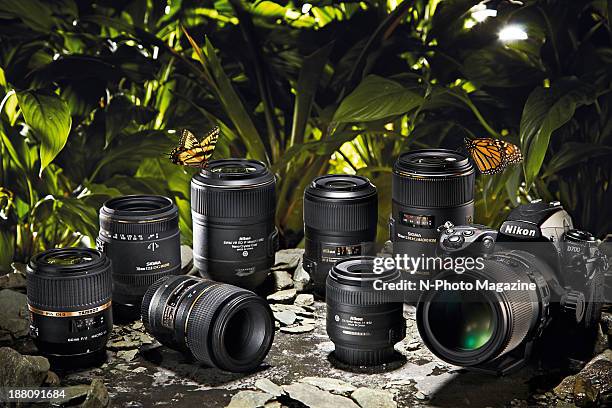 Nikon D700 DSLR with a selection of Nikon-compatible macro lenses photographed against a jungle-like scene, taken on March 26, 2013.