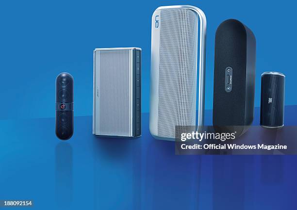 Selection of wireless speakers photographed on a blue background, including Beats by Dr Dre Pill, Bose SoundLink II, Logitech UE Boombox, Creative...