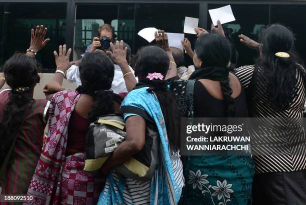 Sri Lankan ethnic Tamil women approach the media bus travelling with British Prime Minister David Cameron during a protest in Jaffna, some 400...