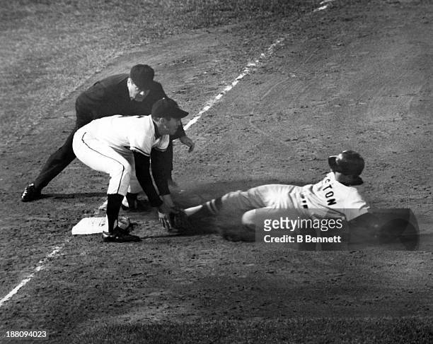 Rico Petrocelli of the Boston Red Sox is tagged out by third baseman Brooks Robinson of the Baltimore Orioles as umpire John Rice waits to make the...