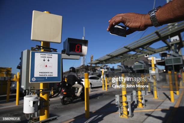 Traveler shows his ID to a radio frequency indentification reader while crossing from Mexico into the United States at the San Ysidro port of entry...