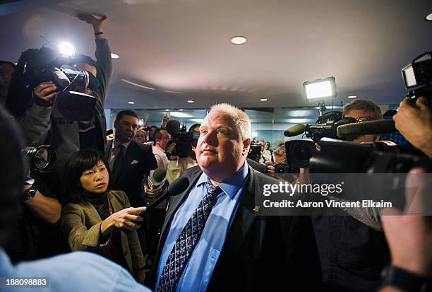 Toronto Mayor Rob Ford stands amid the media at City Hall after City Council stripped him of some management powers on November 15, 2013 in Toronto,...