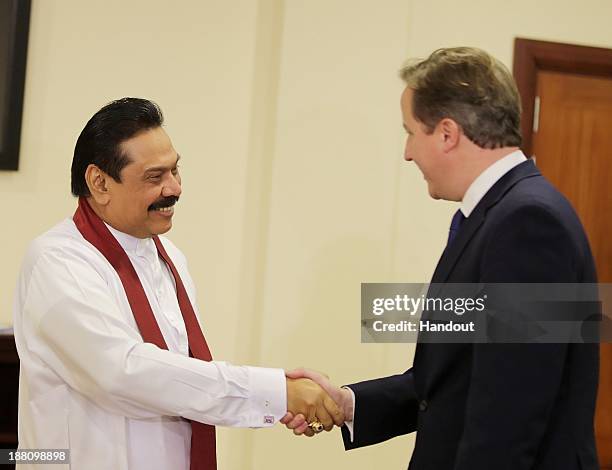 In this handout photo provided by Sri Lankan Government, Sri Lankan President Mhainda Rajapaksa shake hands with United Kingdom Prime Minister, David...