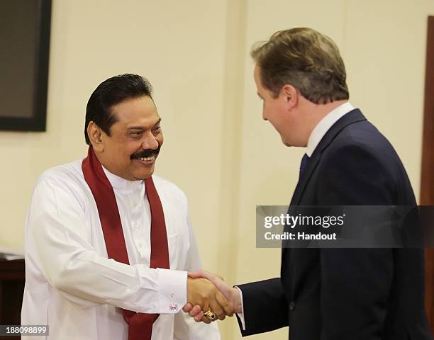 In this handout photo provided by Sri Lankan Government, Sri Lankan President Mhainda Rajapaksa shake hands with United Kingdom Prime Minister, David...