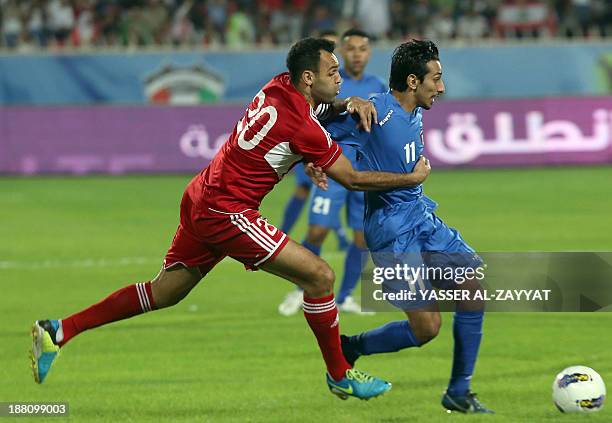 Kuwait's Said Al-Hashan is defended by Lebanon's Roda Antar during their AFC Asian cup match in Kuwait city on November 15, 2013. AFP PHOTO/YASSER...