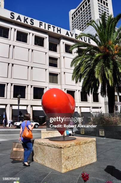 Shopper stops to admire an outdoor sculpture near the Saks Fifth Avenue store located in San Francisco's upscale Union Square shopping district.