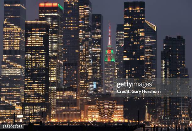 The Empire State Building is lit in holiday colors for Christmas between the Hudson Yards towers in New York City on December 24 as seen from...