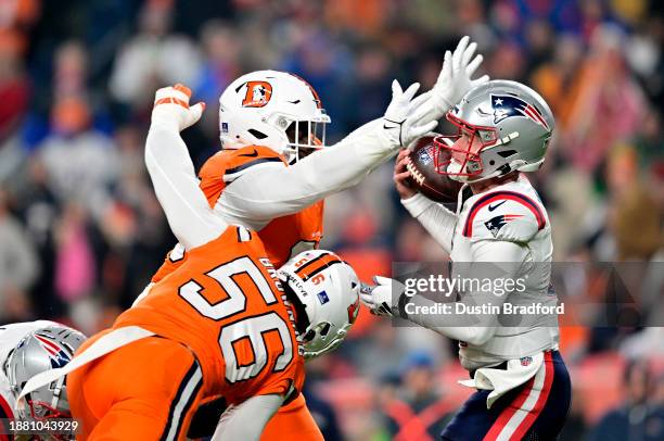 Defensive tackle D.J. Jones of the Denver Broncos forces a fumble on quarterback Bailey Zappe of the New England Patriots on the first play of the...
