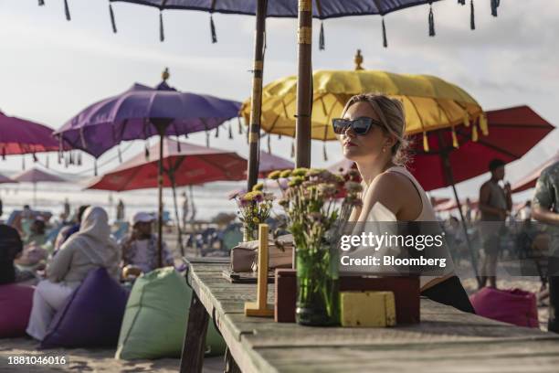 Woman sits at a beach club at Double Six beach in Seminyak, Bali, Indonesia, on Tuesday, Dec. 26, 2023. Indonesia plans to let more nationalities...