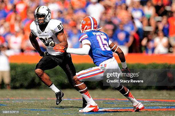 Jordan Matthews of the Vanderbilt Commodores breaks a tackle by Loucheiz Purifoy of the Florida Gators during a game at Ben Hill Griffin Stadium on...