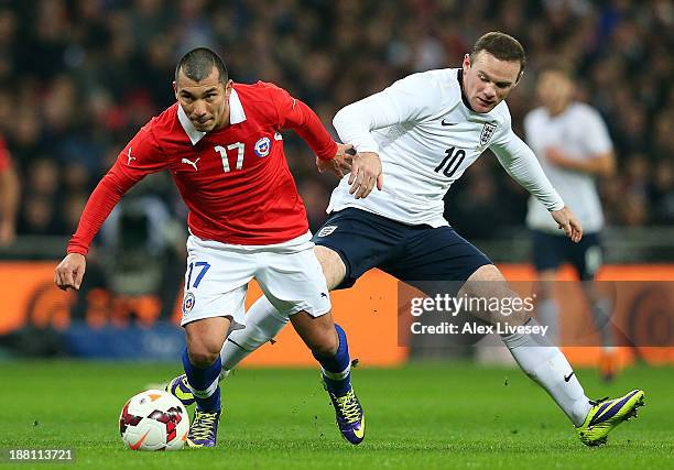 Gary Medel of Chile evades Wayne Rooney of England during the international friendly match between England and Chile at Wembley Stadium on November...