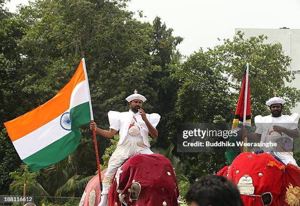 Man dressed traditional costume hold Indian national flag as get on elephant during the opening ceremony of Commonwealth Heads of Government Meeting...