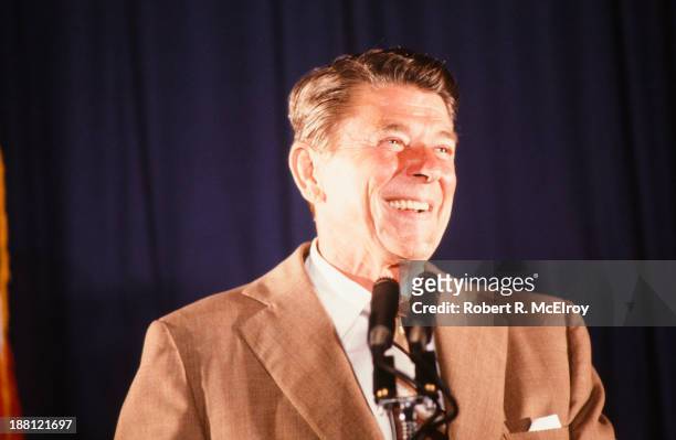 During his presidential campaign, American politician Ronald Reagan smiles from behind a pair of microphones, Florida, June 1980.