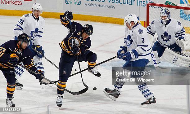 Steve Ott and Ville Leino of the Buffalo Sabres try to tip the puck in front of Dion Phaneuf and goaltender Jonathan Bernier of the Toronto Maple...
