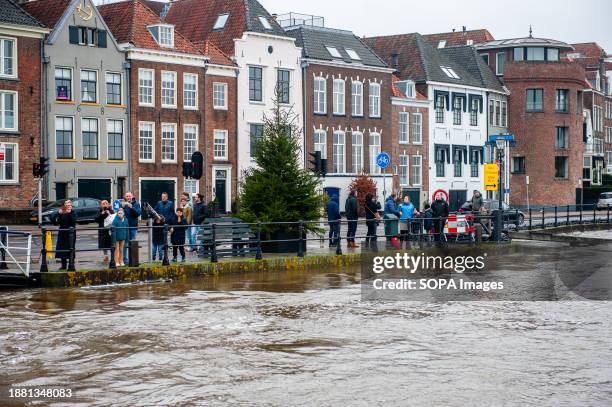 View from the river of people looking at the high water level. Due to the rising water in the IJssel River, the municipality of the Deventer is...
