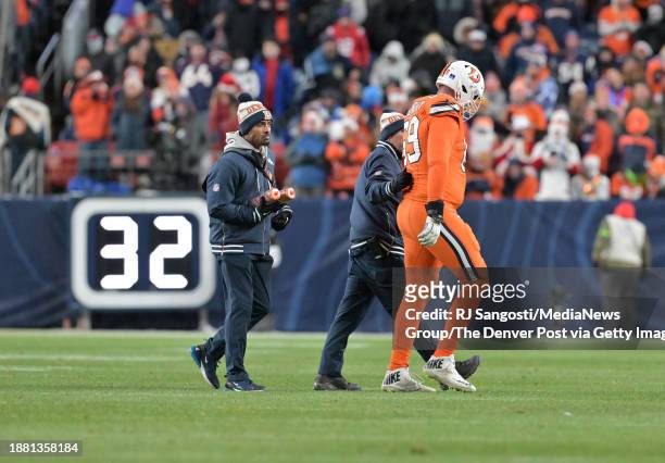 Denver Broncos offensive tackle Mike McGlinchey is helped off the field after getting hurt during the second half of the game at Empower Field at...