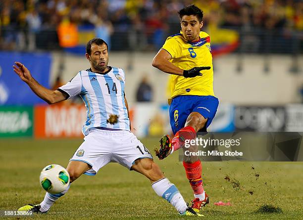 Midfielder Christian Noboa of Ecuador plays the ball against midfielder Javier Mascherano of Argentina at MetLife Stadium on November 15, 2013 in...