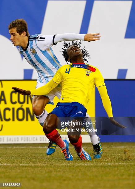 Defender Lucas Orban of Argentina knocks defender Juan Carlos Paredes of Ecuador to the ground at MetLife Stadium on November 15, 2013 in East...