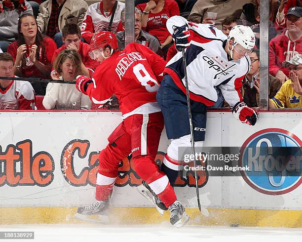 Justin Abdelkader of the Detroit Red Wings hits Alexander Urbom of the Washington Capitals during an NHL game at Joe Louis Arena on November 15, 2013...