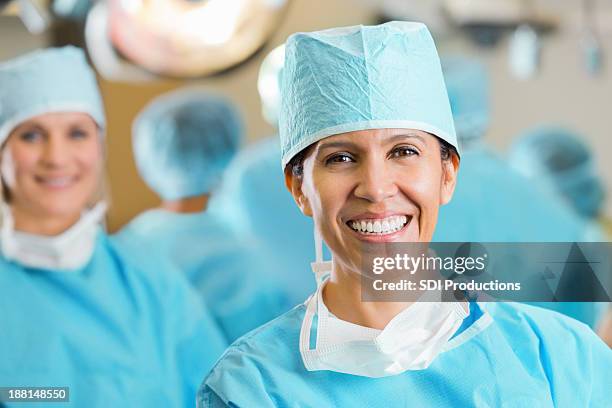 confident hispanic surgeon in hospital operating room - operating gown stock pictures, royalty-free photos & images