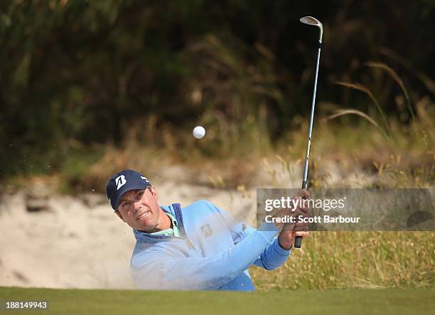 Matt Kuchar of the USA plays out of a bunker on the 15th hole during round three of the 2013 Australian Masters at Royal Melbourne Golf Course on...