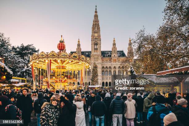 carousel on town square in vienna full of people at time of christmas market - vienna holiday fair stock pictures, royalty-free photos & images