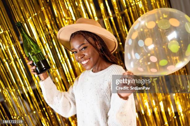 party portrait of a beautiful african ethnicity woman posing against the gold fringe curtains - gold fringe stock pictures, royalty-free photos & images