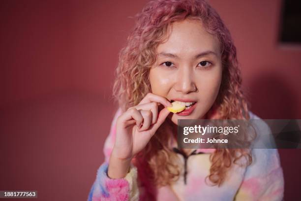 woman biting a gummy candy - gummy candy stock pictures, royalty-free photos & images